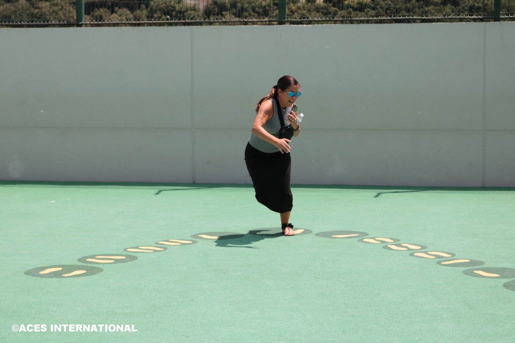 A group member from the Educators Field Study dances on footprint artwork.